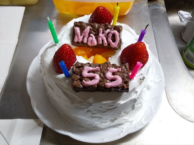 できあがったケーキ。上部に苺3個とロウソク5本、「MaKO」「55」と書かれたプレートが乗っている